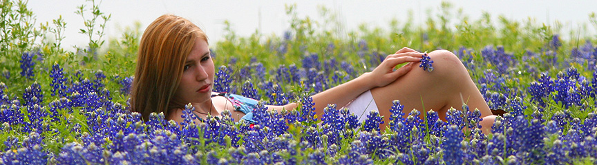 Girl get her picture taken with Bluebonnets in Brenham Texas.